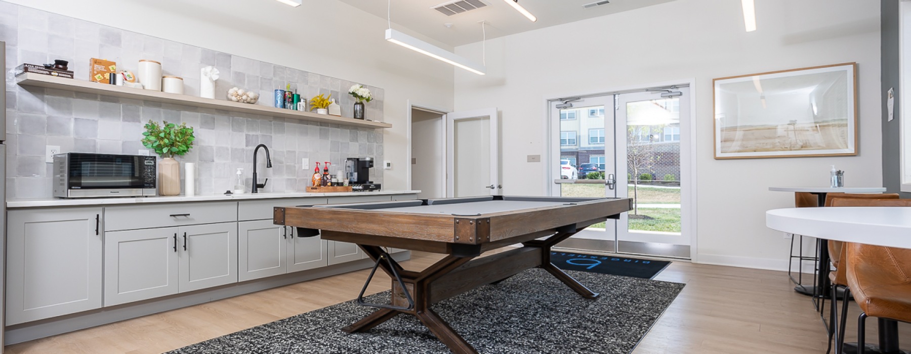 Large room with pool table and galley kitchen