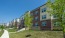 Apartment building exterior with trees and sidewalk