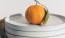 a round orange fruit on a white plate